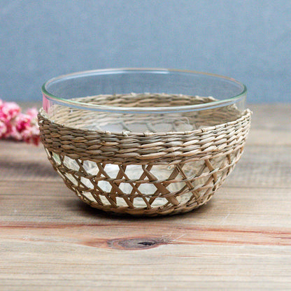 Small bowl with a seagrass cage on the outside on a wooden table