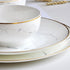 White ceramic plates with gold rims on a light background