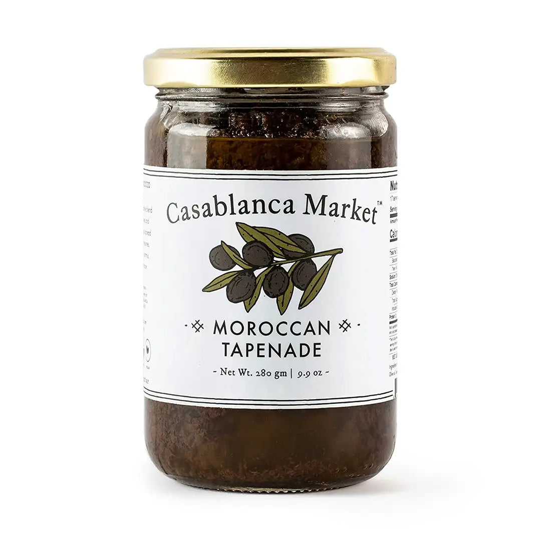 A glass jar of Casablanca Market Moroccan Tapenade with a white label and a gold metal lid, set against a plain white background.
