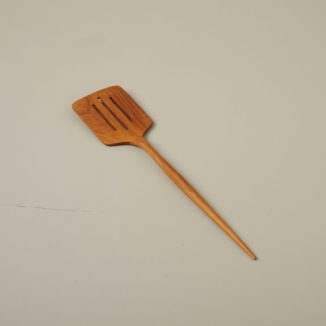 Teak wood spatula on a beige background