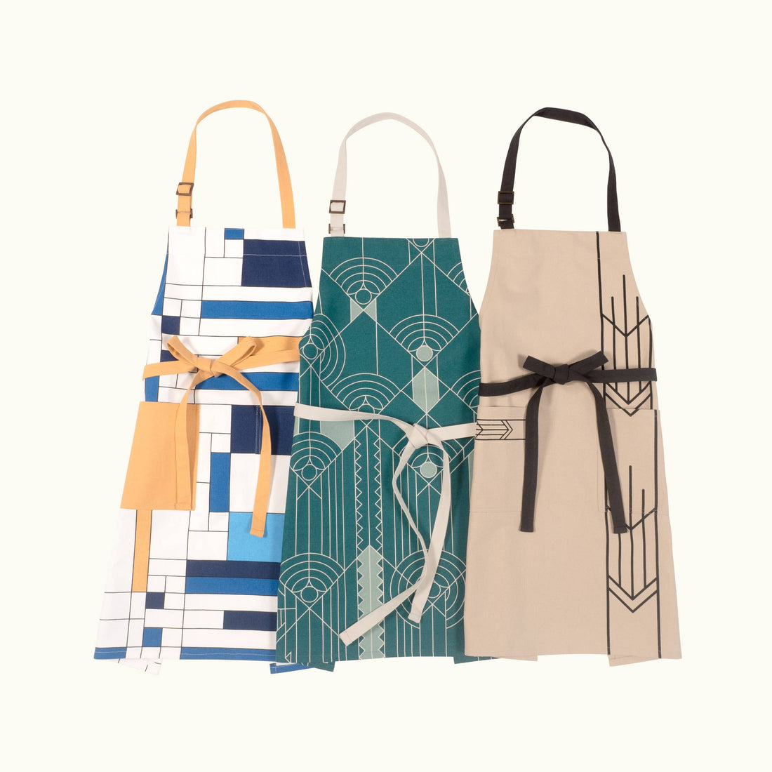 Three aprons with geometric patterns on a white background
