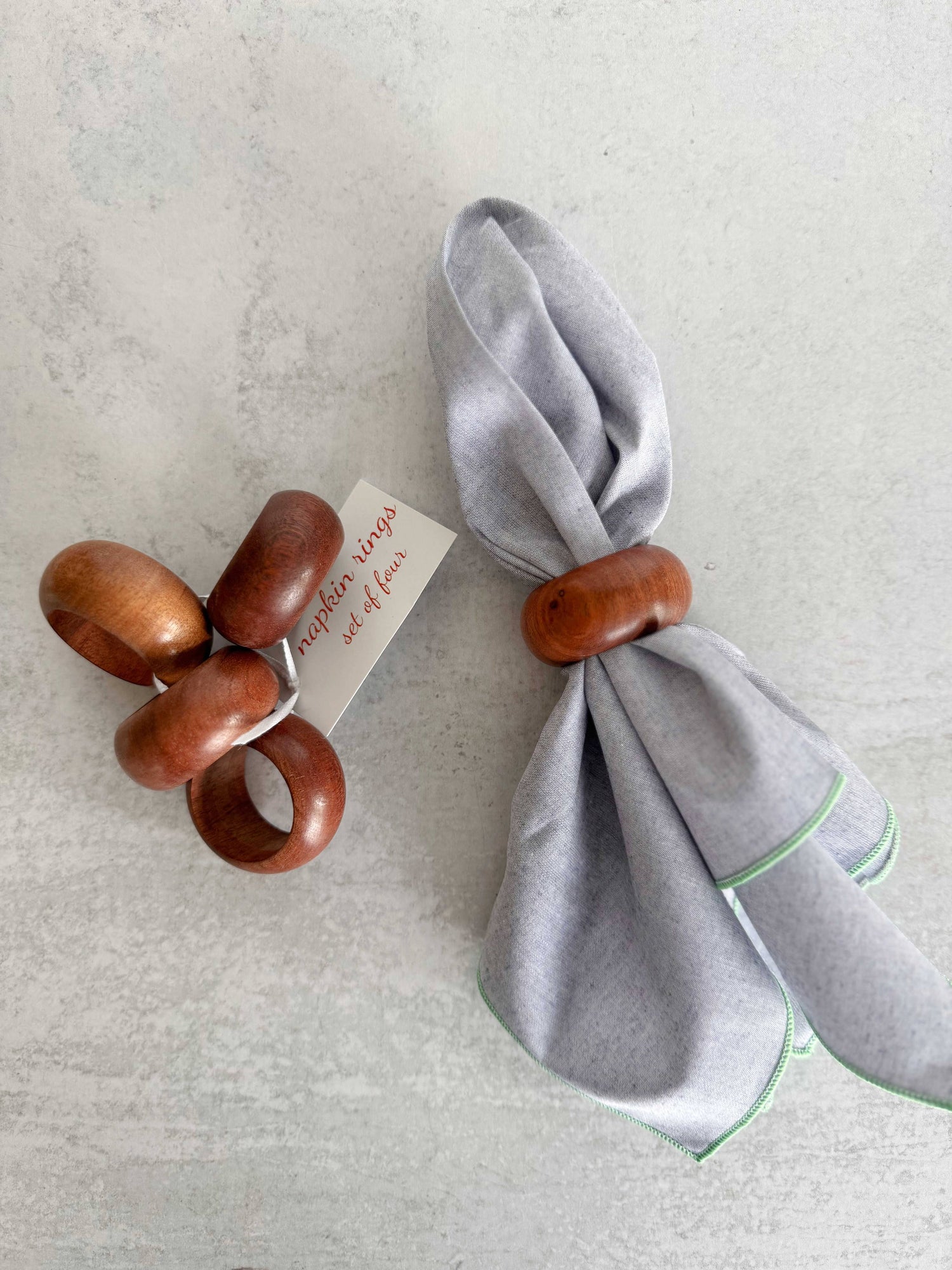 Set of wooden napkin rings with a gray napkin on a light background