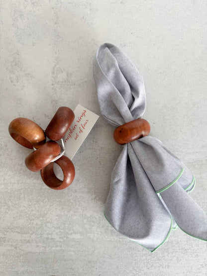Set of wooden napkin rings with a gray napkin on a light background