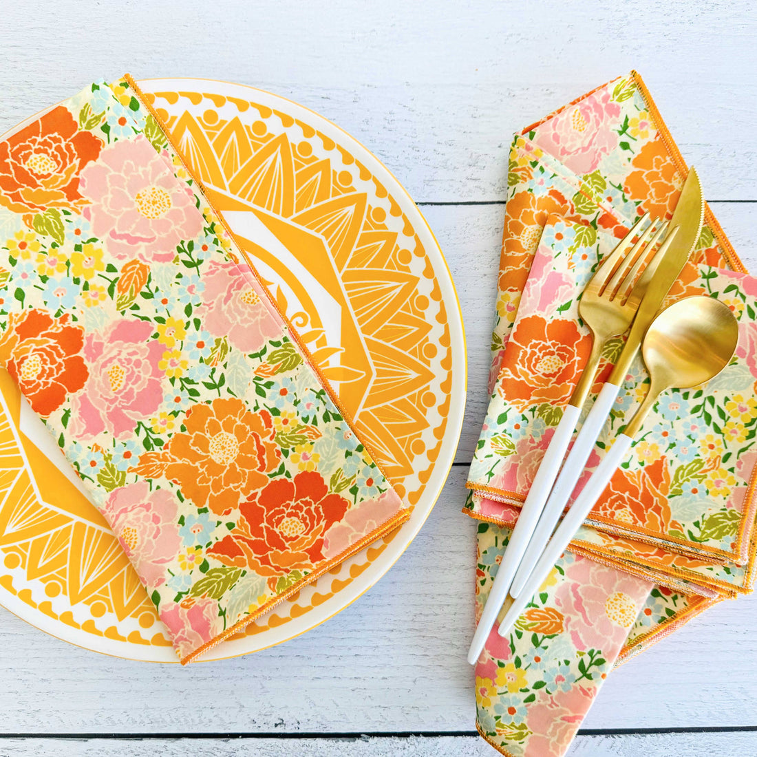 Floral-patterned plates, napkins, and cutlery on a white wooden surface