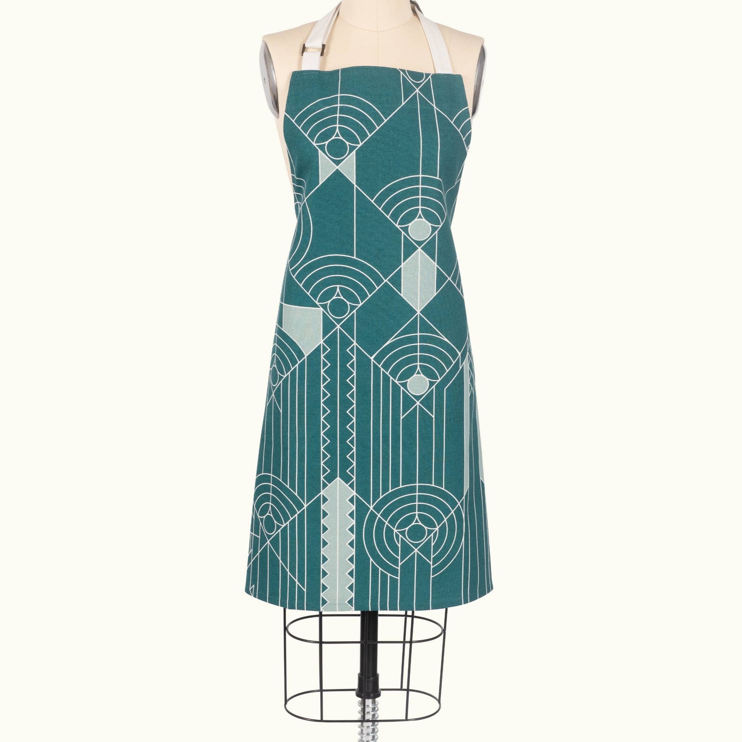 Teal apron with geometric pattern on a mannequin against a white background