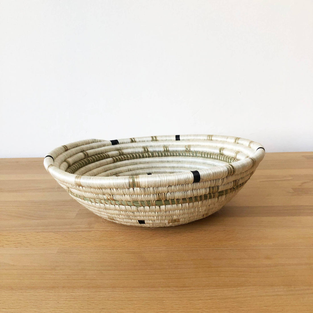Woven basket on a wooden surface with a white background