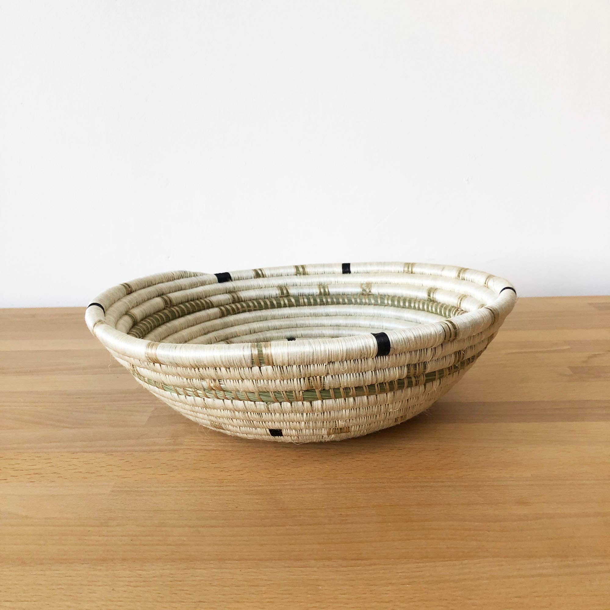 Woven basket on a wooden surface with a white background