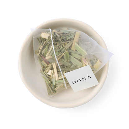 Tea bag with herbs in a white bowl on a white background, featuring the brand &