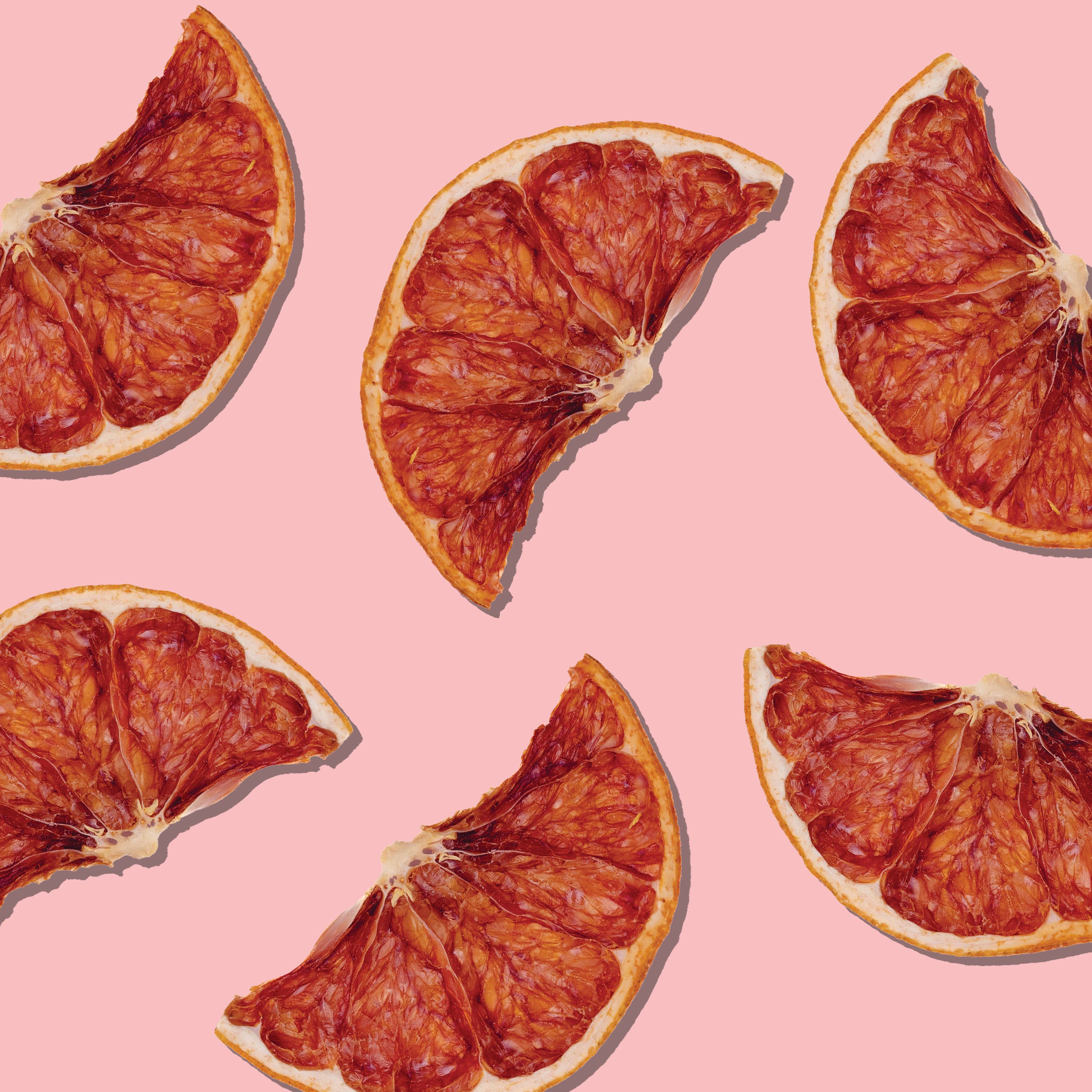 Dried grapefruit slices on a pink background