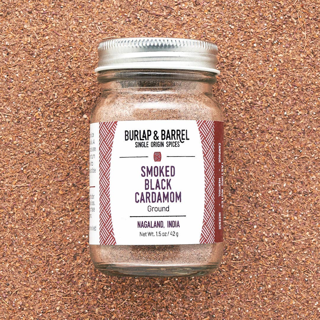 Jar of Burlap &amp; Barrel Smoked Black Cardamom on a cork background