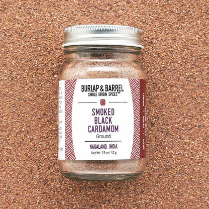 Jar of Burlap &amp; Barrel Smoked Black Cardamom on a cork background