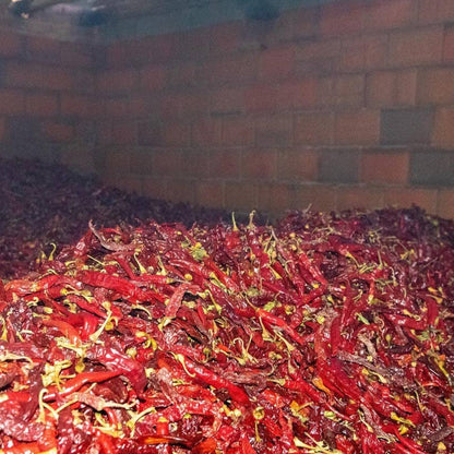 Pile of red chili peppers with a brick wall background