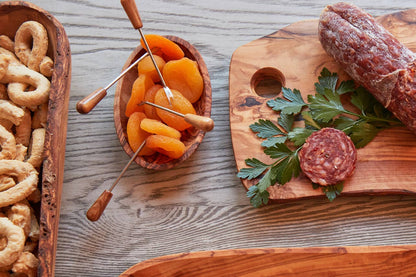 Italian Olivewood Aperitivo Bowl with dried apricots next to a wood platter with salami