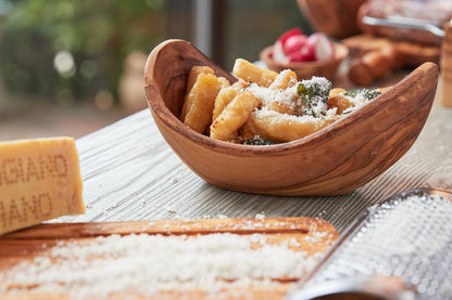 Italian Olivewood Serving Bowl filled with gnocchi with a cheese grater in the foreground