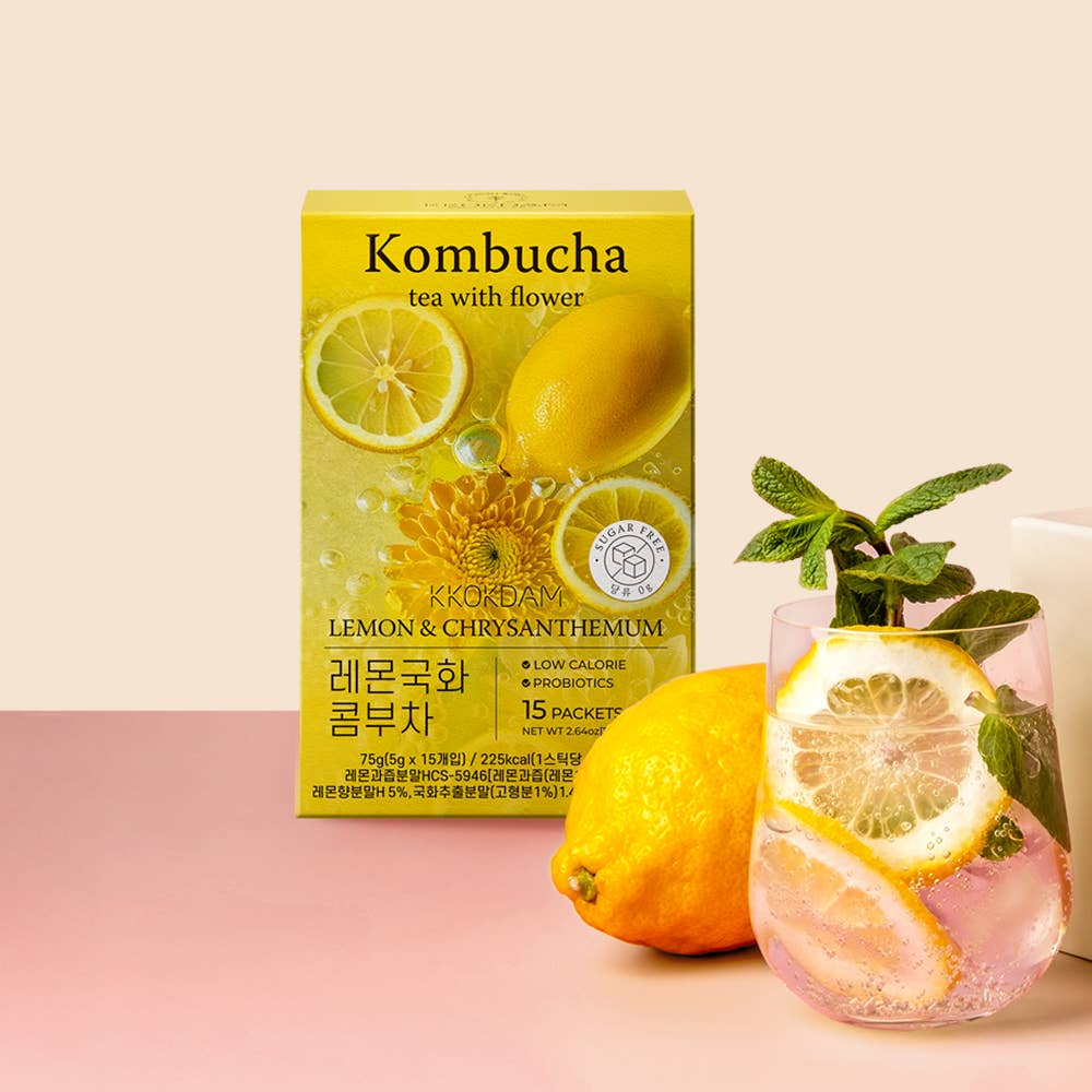 Kombucha tea package with lemon slices and a glass of lemonade on a pink background