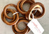 Set of wooden bangle napkin rings with a tag on a neutral background