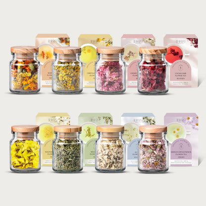 Collection of glass jars with dried herbs and flowers, each labeled with colorful packaging.