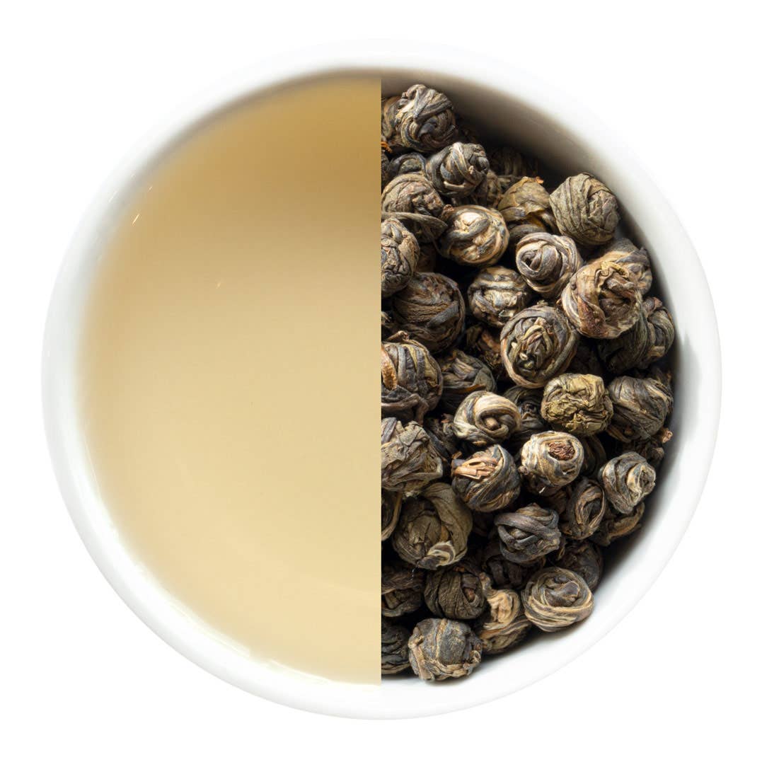 Tea leaves and brewed tea in a white cup on a white background
