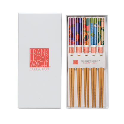Set of chopsticks with colorful handles in a white box labeled &