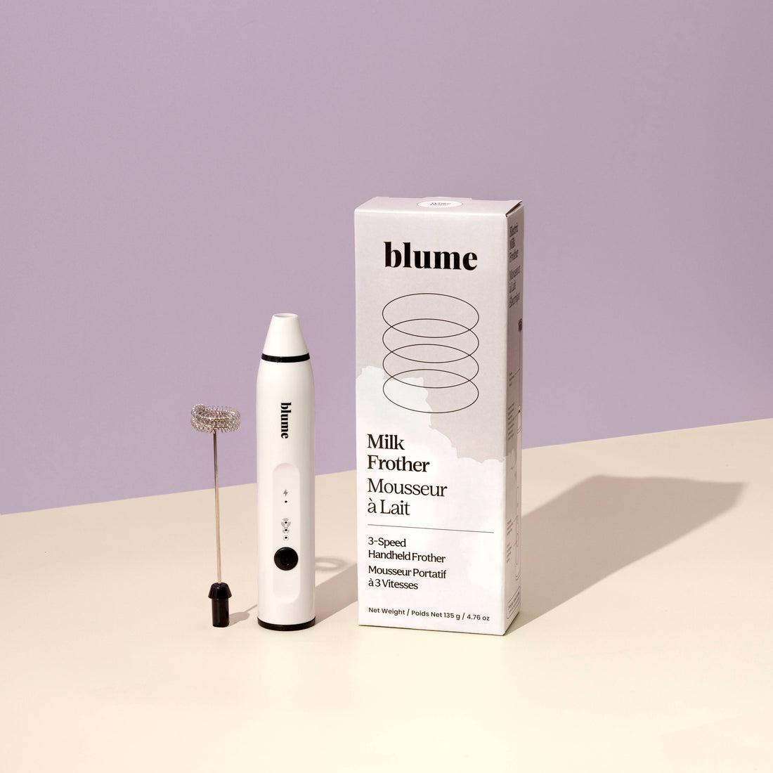 Blume Milk Frother with packaging on a light purple background