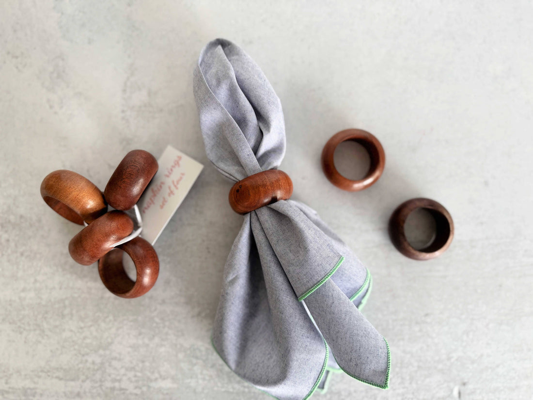Wooden napkin rings on a gray napkin with a white background