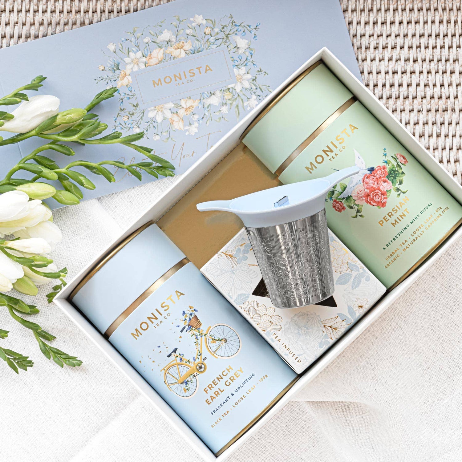 Tea packaging with Monista branding on a floral background