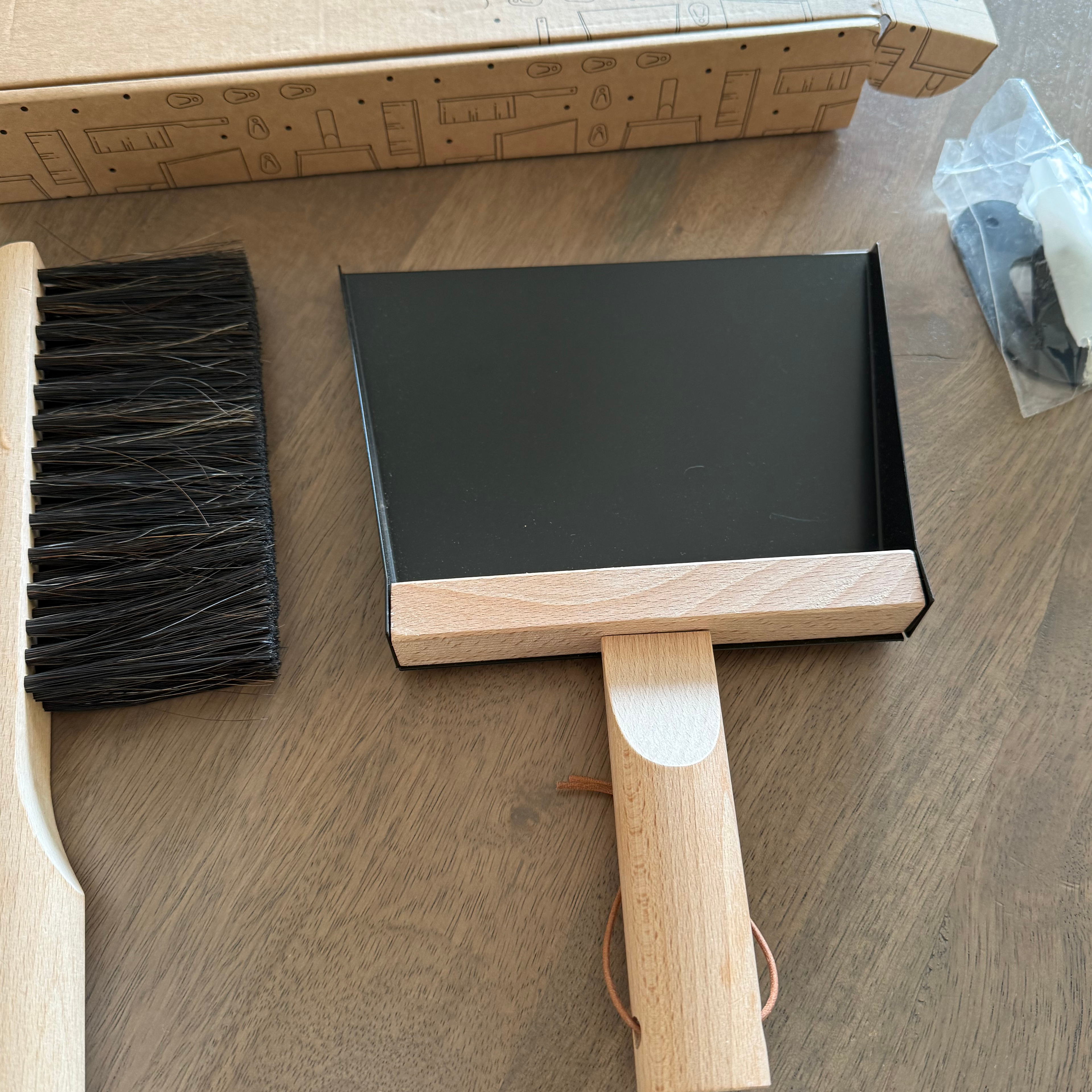 Cleaning tool set with brush and dustpan on a wooden surface