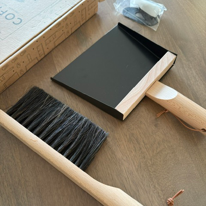 Cleaning brush and dustpan on a wooden floor