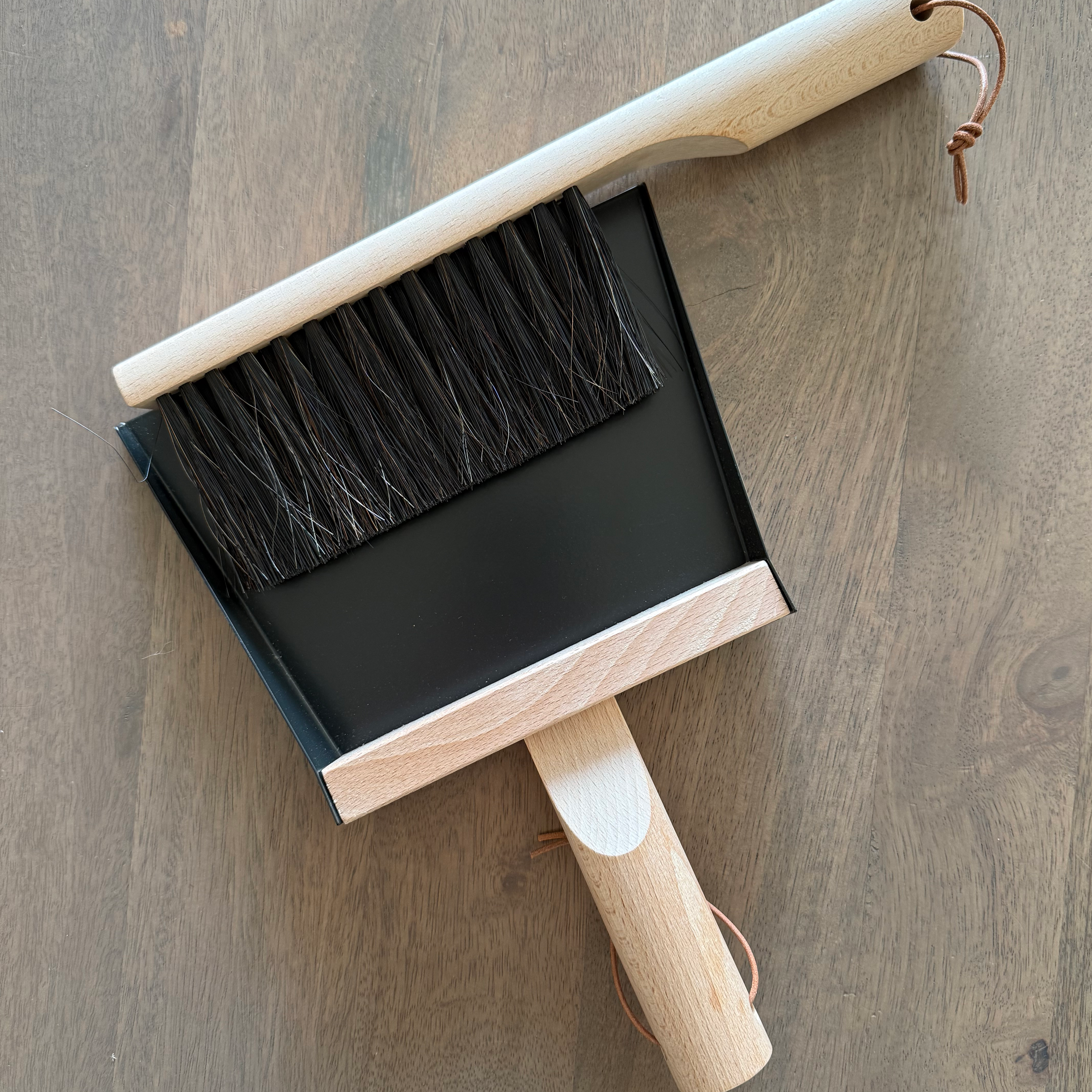 Dustpan and brush set on a wooden surface