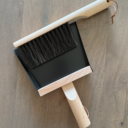 Dustpan and brush set on a wooden surface