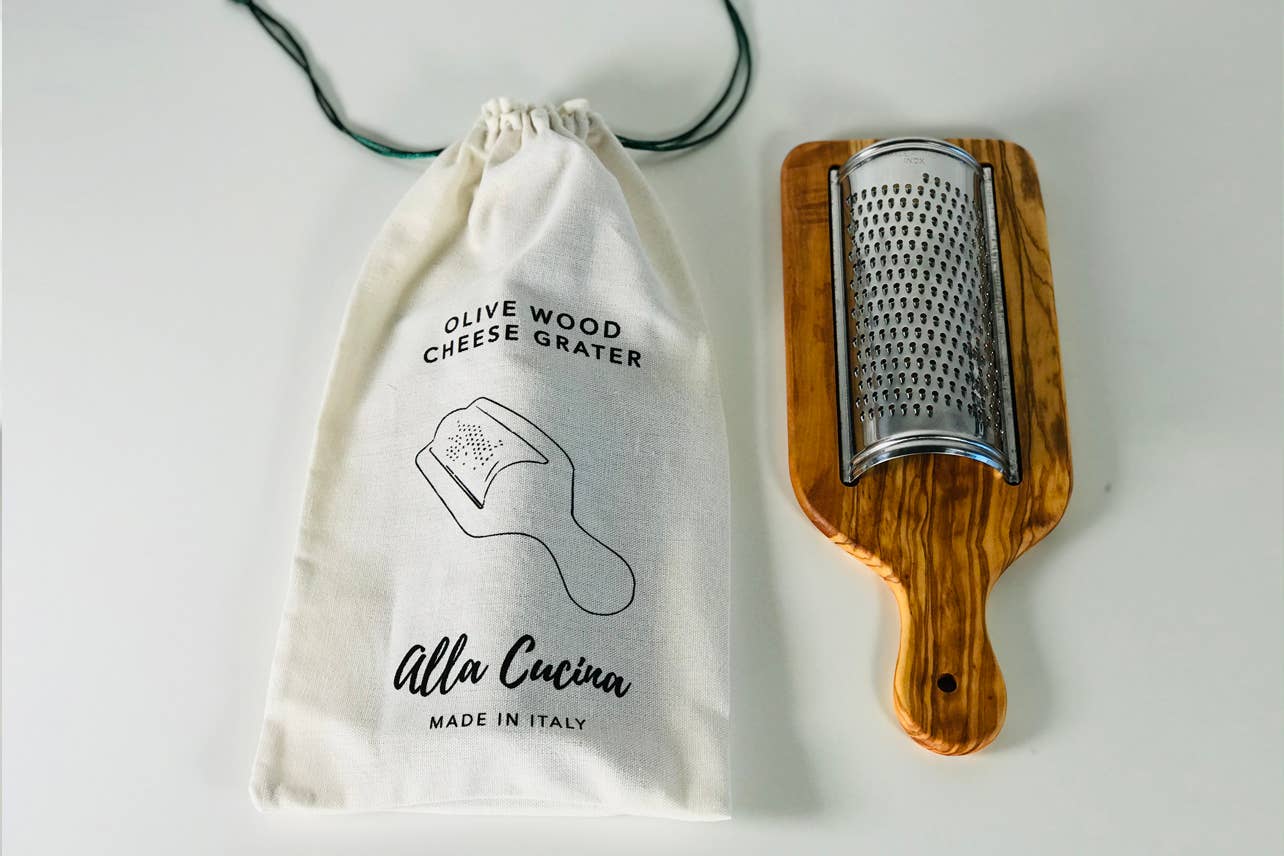 Italian Olivewood Flat Cheese Grater with a branded drawstring bag on a light background