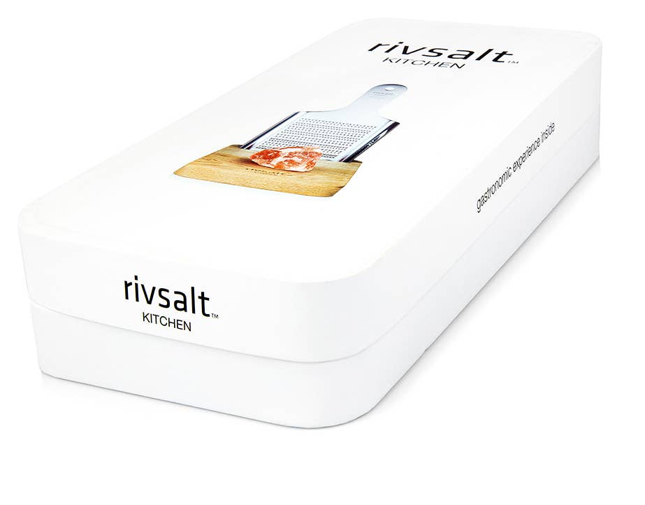 A box of rivsalt kitchen box with a salt grater and salt rock on a wood stand