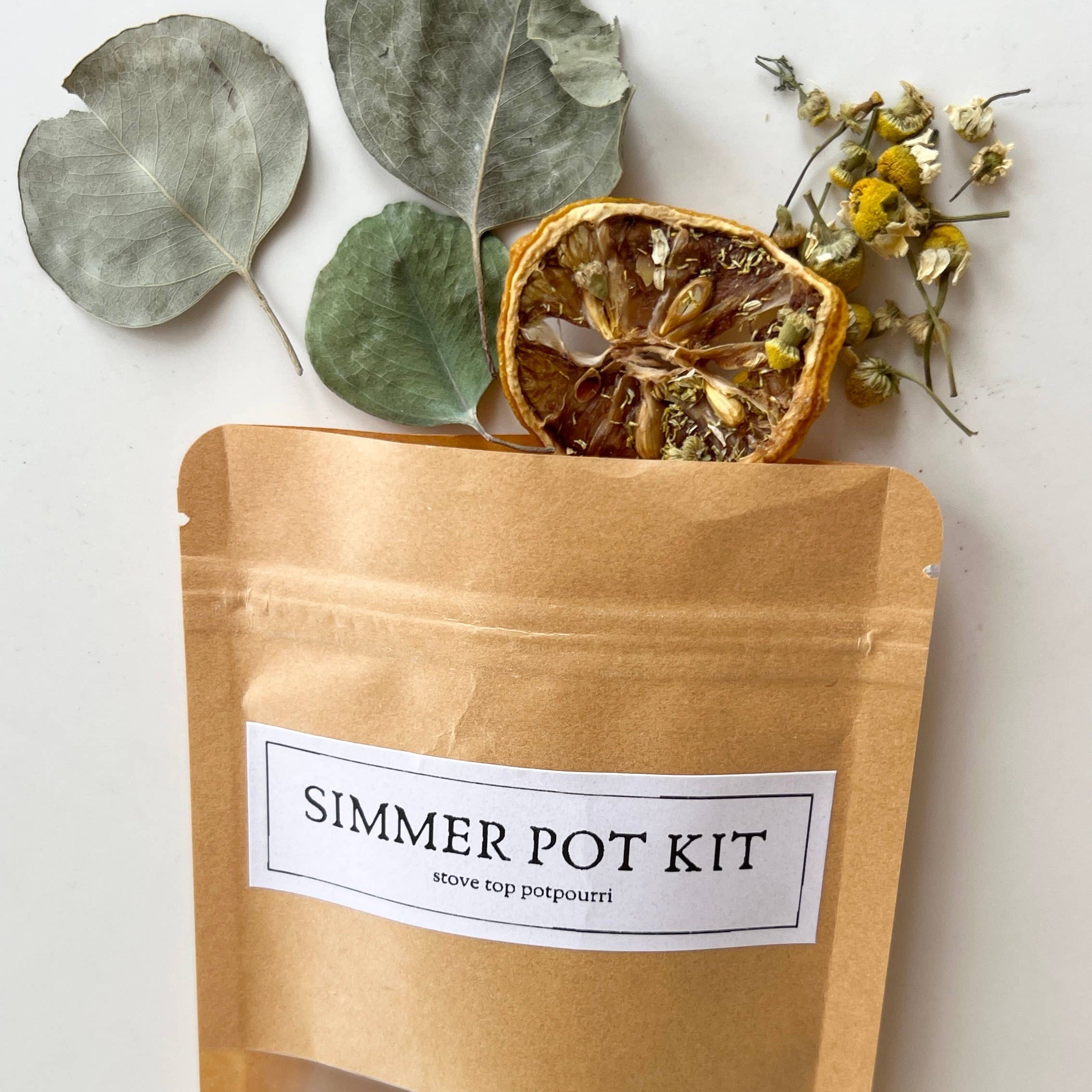 Simmer pot kit packaging with dried leaves and flowers on a white background