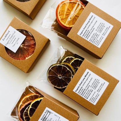 Small brown boxes containing dried orange and lemon slices on a white background