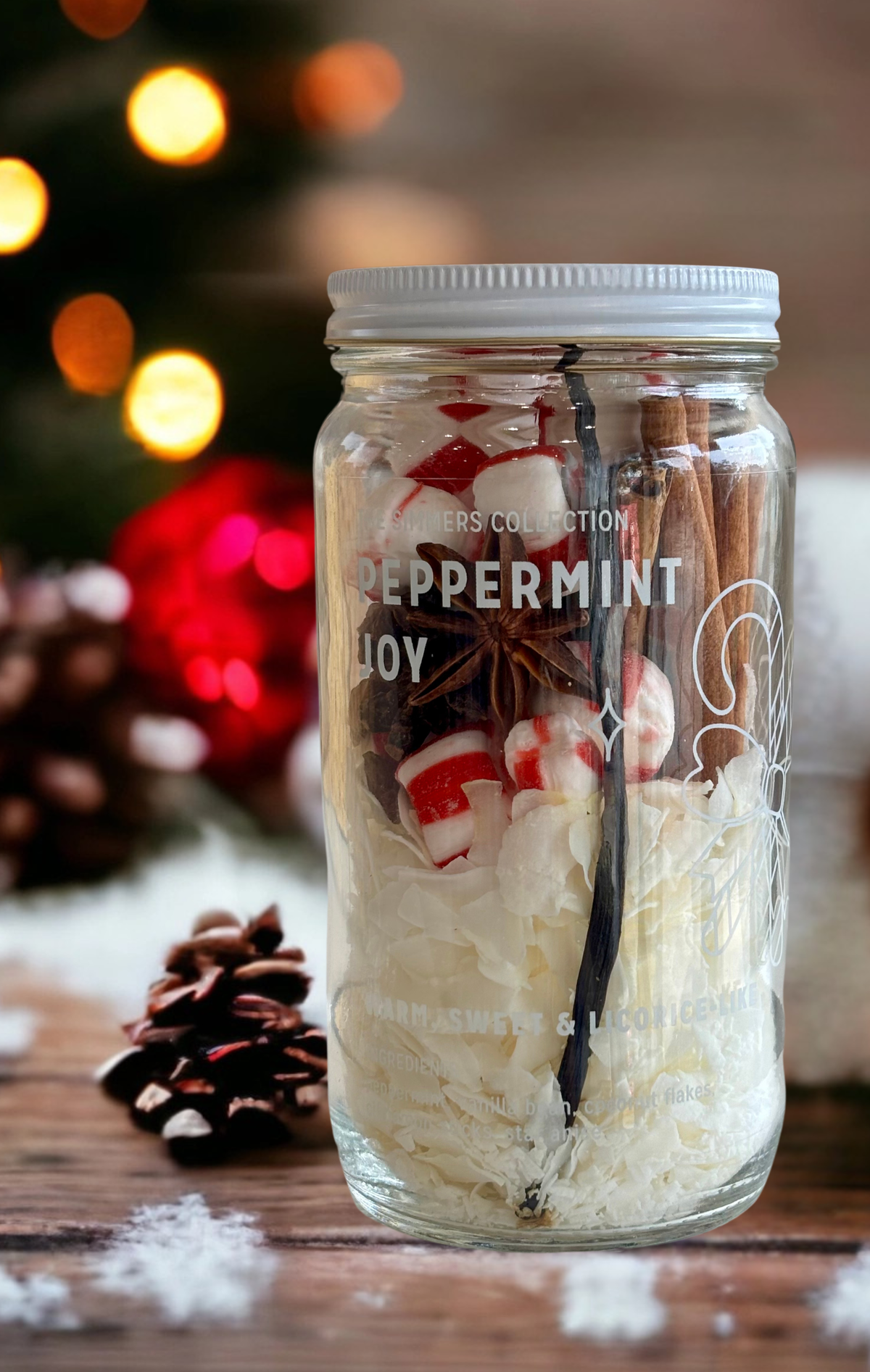 A clear glass mason jar filled with holiday spices and treats, labeled &