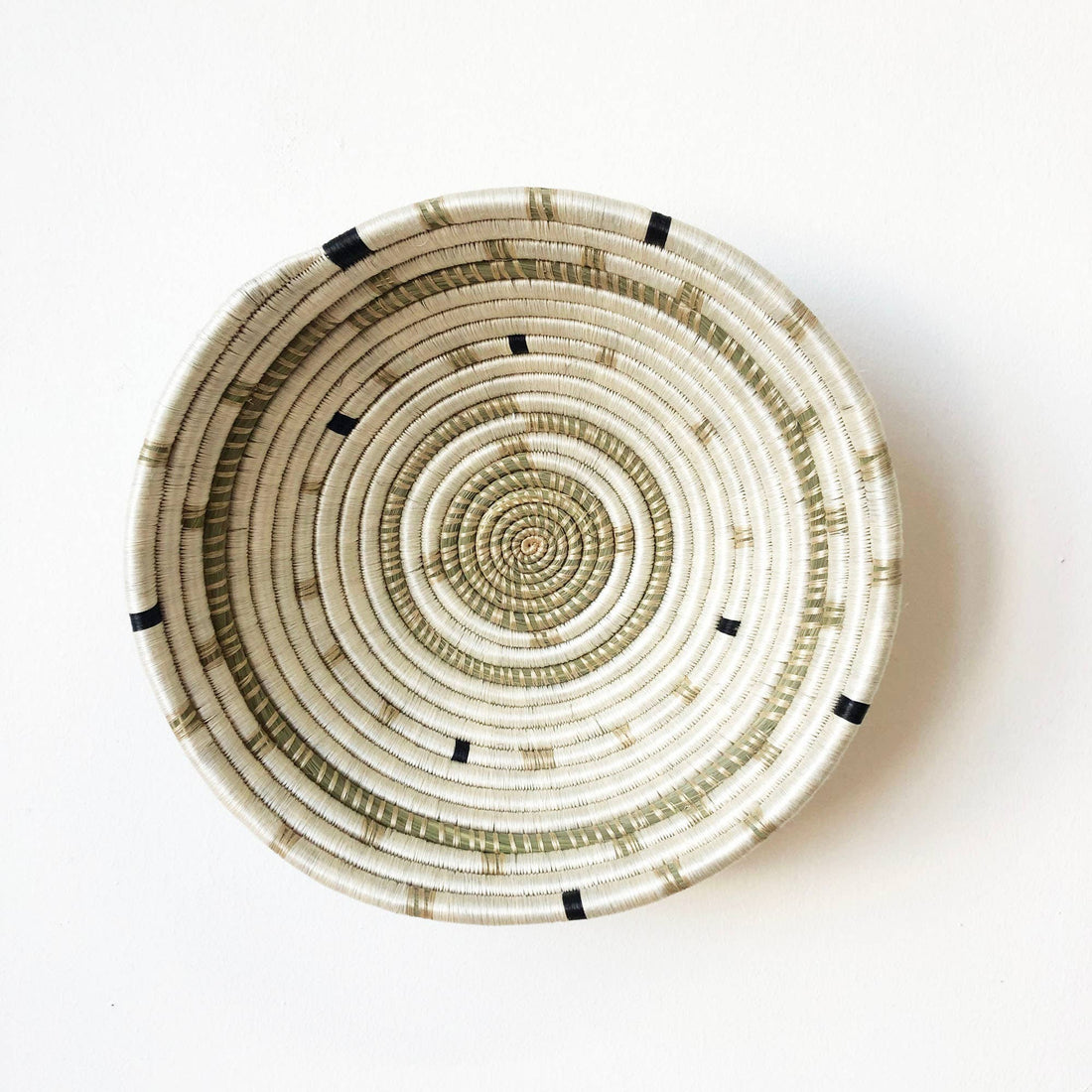 Woven basket with concentric circle pattern on a white background
