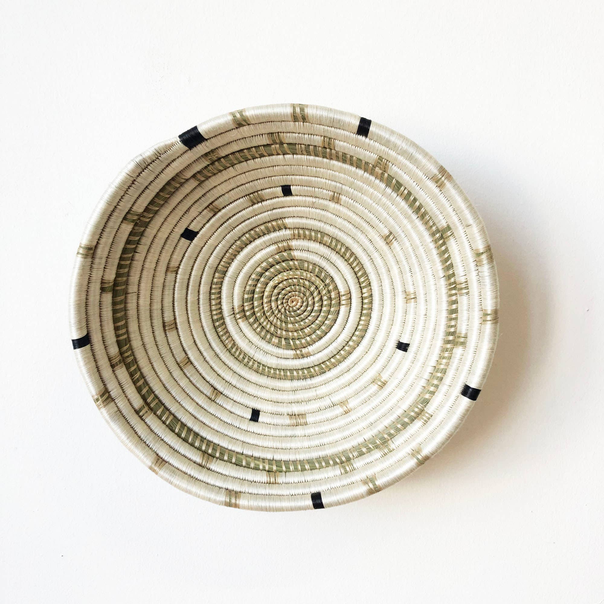 Woven basket with concentric circle pattern on a white background