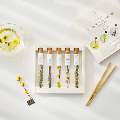 Set of flower tea sticks in a white box with packaging on a light surface.