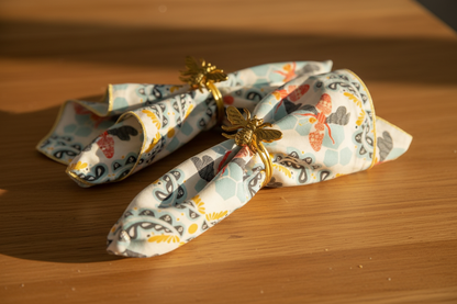 Honey Bee Napkins with honey bee napkin rings on a wood surface