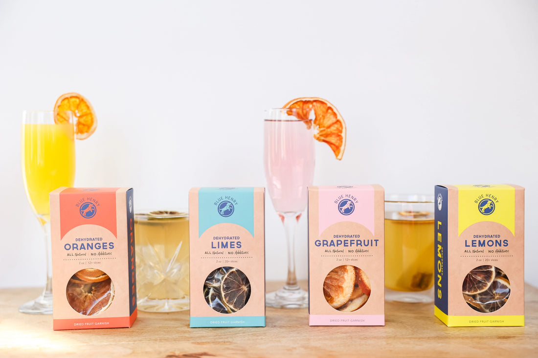 Four boxes of different fruit flavors with glasses of drinks on a wooden surface.