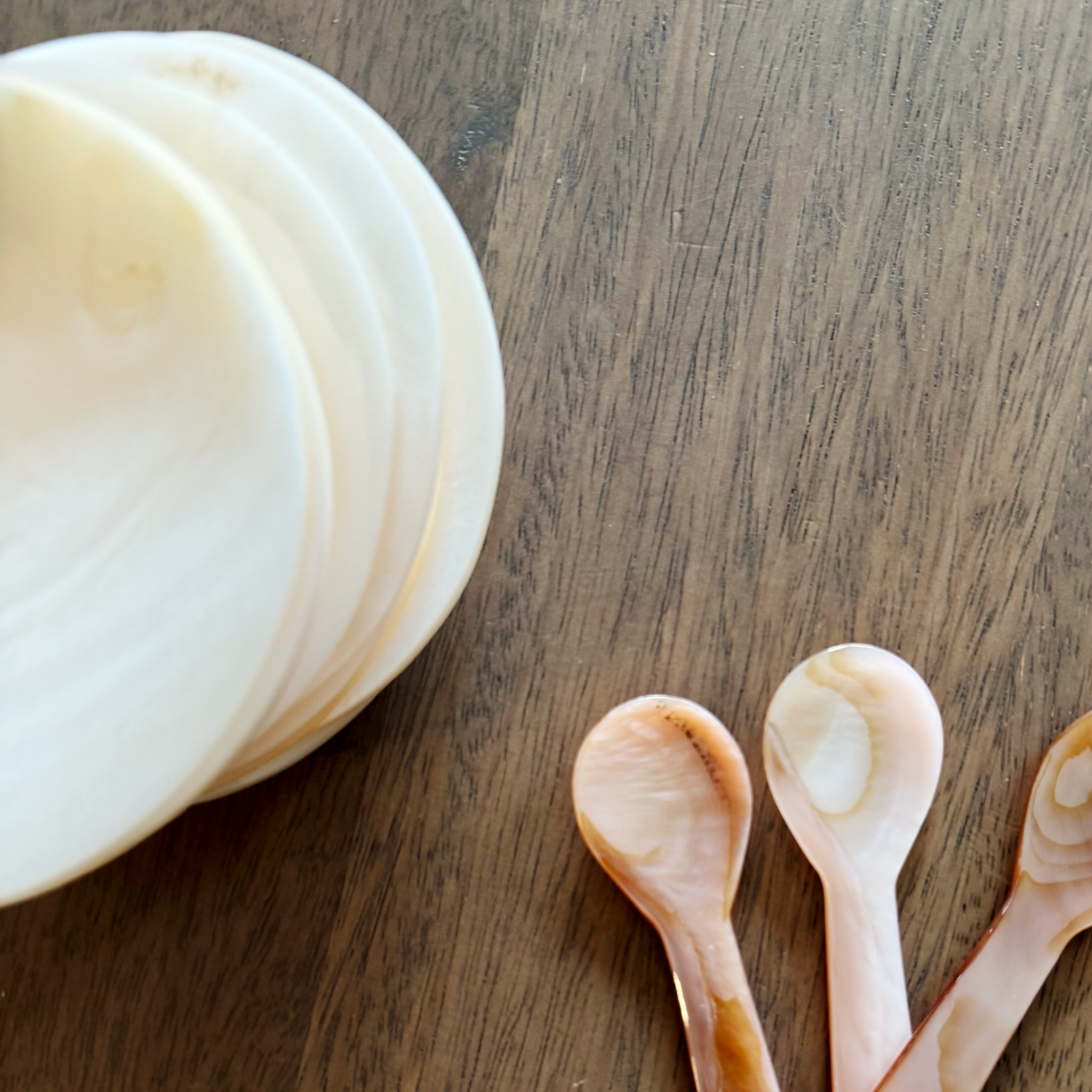 pearl bowls and spoons on a wooden surface