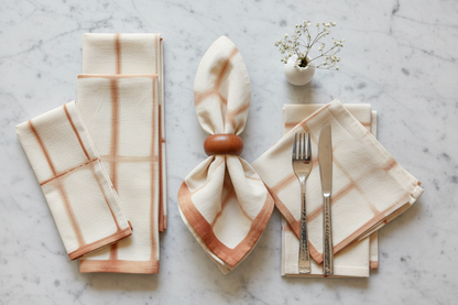 Cream and orange Shibori Napkins + Wood Round Napkin Rings as part of a table setting