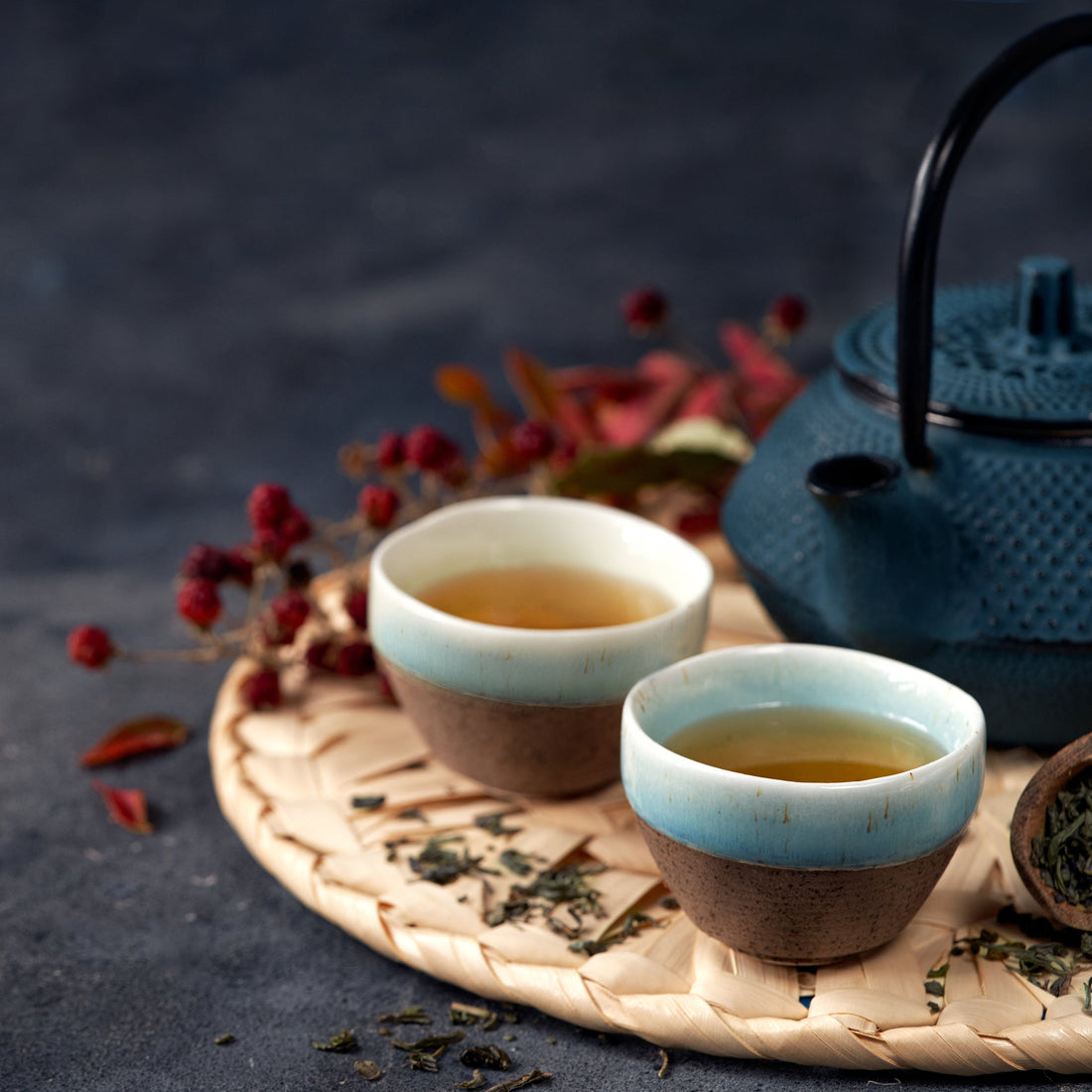 Tea set with two cups and a teapot on a dark surface